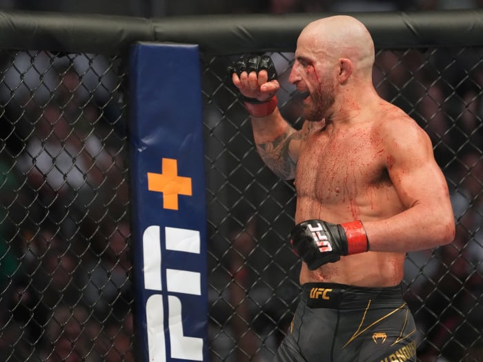 Alexander Volkanovski (red gloves) reacts after defeating Max Holloway (blue gloves) during UFC 276 at T-Mobile Arena.